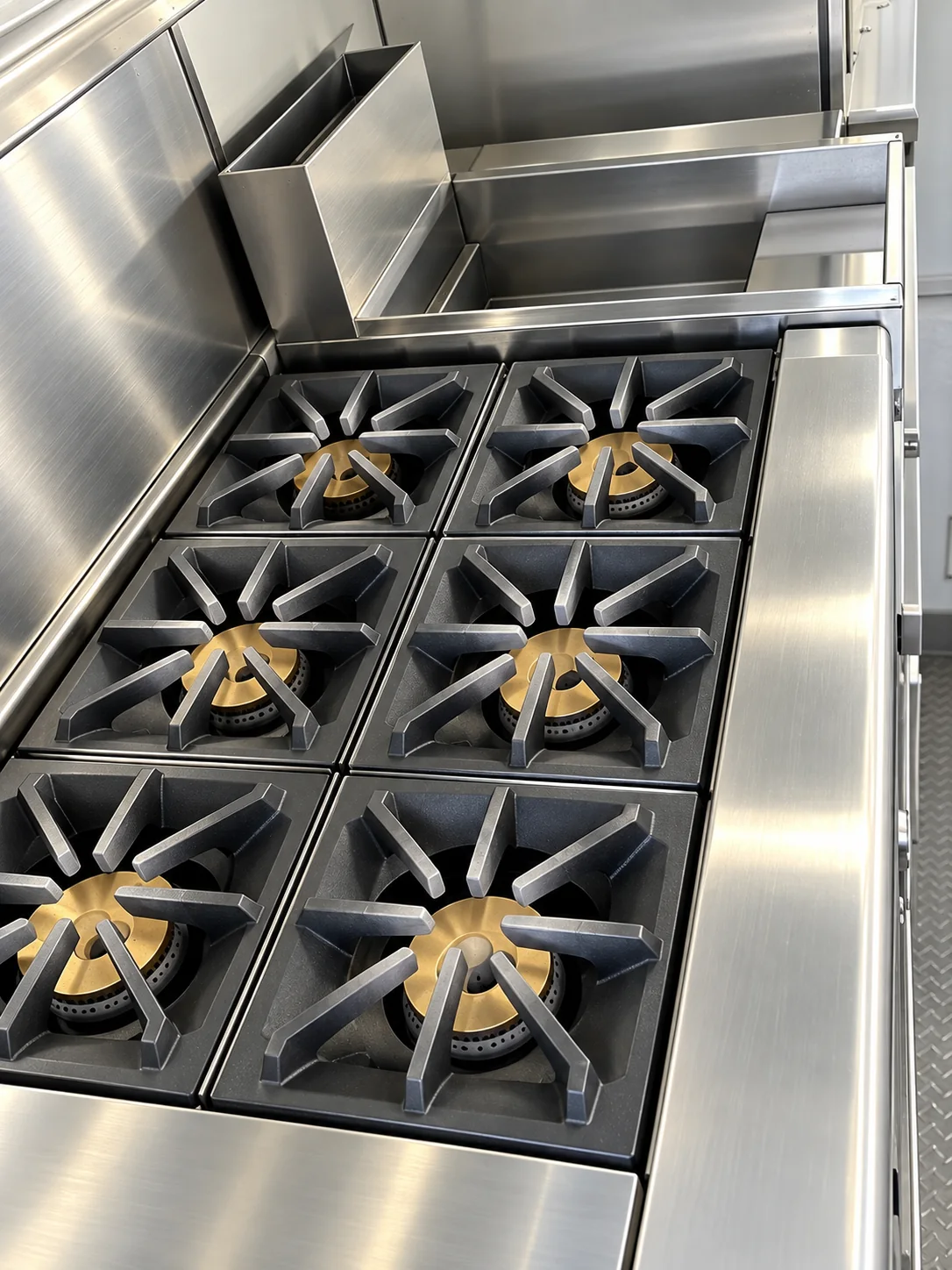 Commercial gas range beneath an exhaust hood