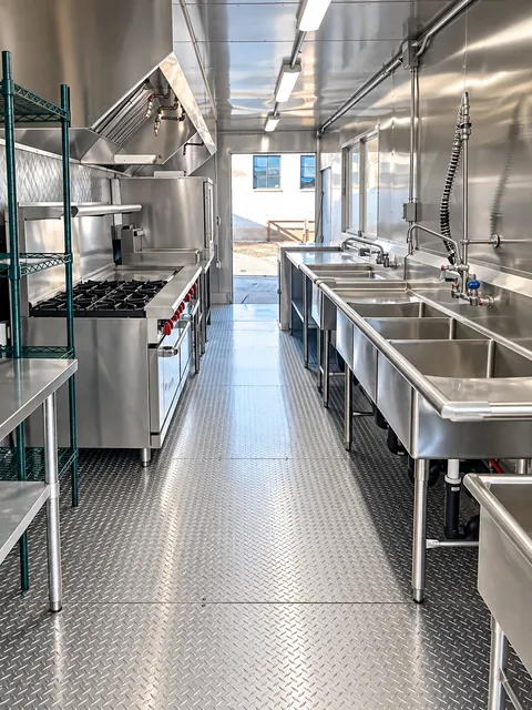Mobile kitchen interior with storage, prep, and wash areas